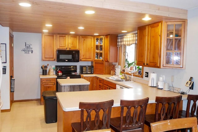 kitchen with wood ceiling, kitchen peninsula, a breakfast bar, and black appliances