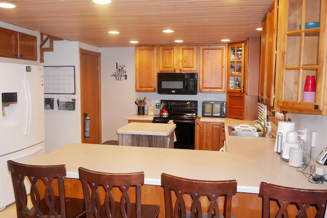 kitchen featuring sink, kitchen peninsula, black appliances, a breakfast bar, and wood ceiling