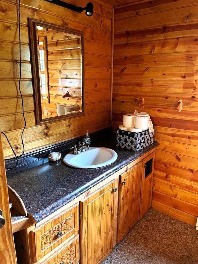 bathroom with vanity and wooden walls