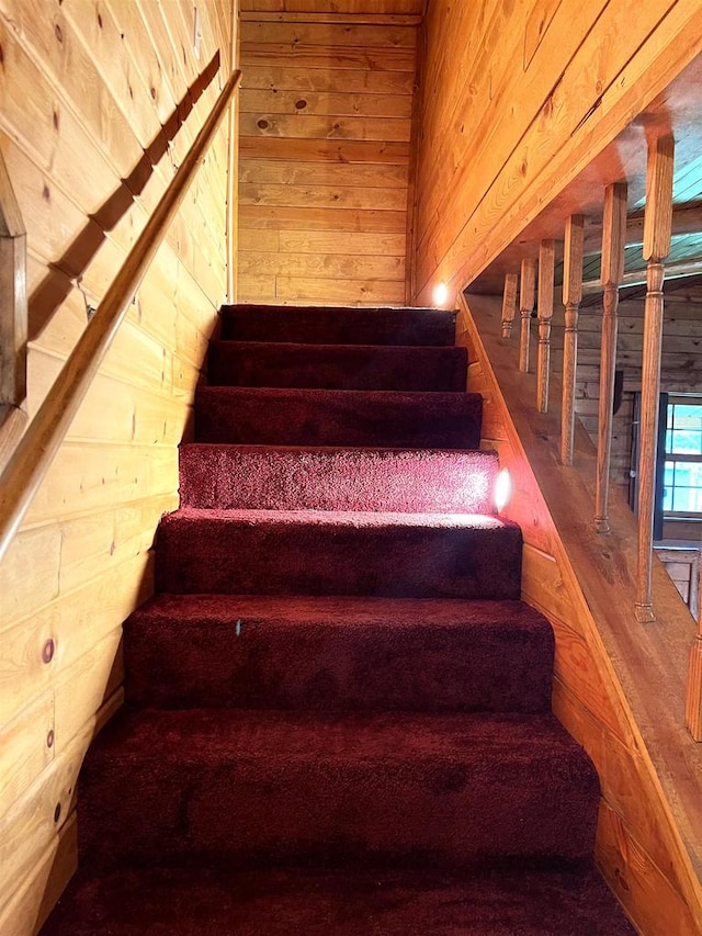 stairway featuring wooden walls and wood-type flooring