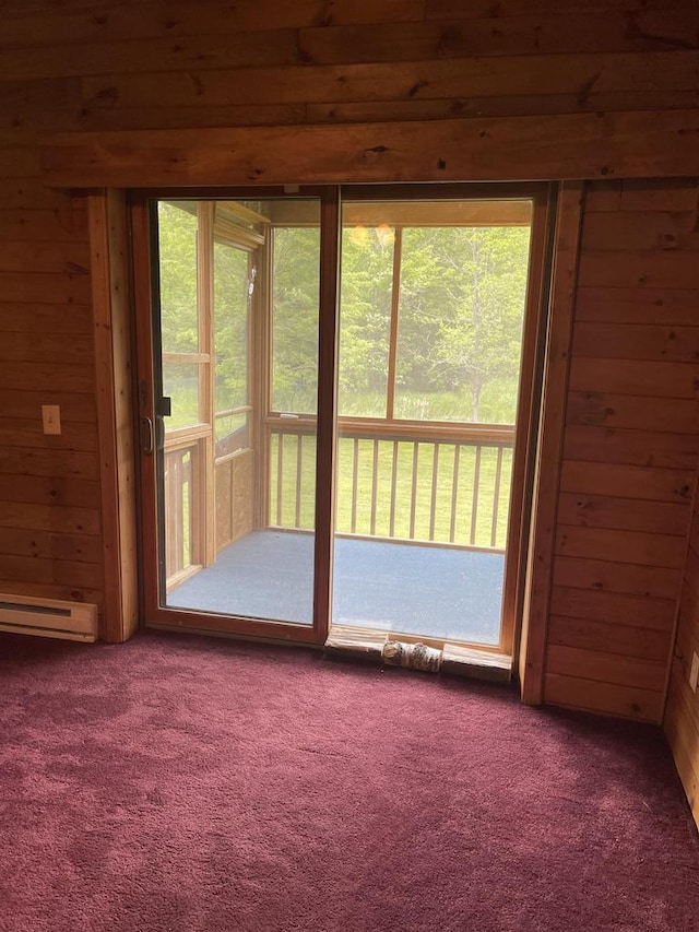 interior space with carpet flooring, wooden walls, and baseboard heating