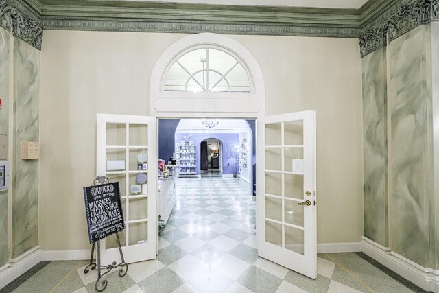 foyer entrance featuring french doors, crown molding, and a high ceiling