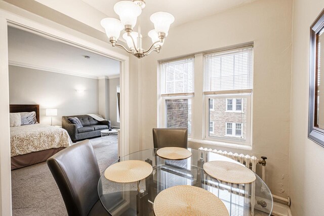 dining room featuring a chandelier, carpet floors, and crown molding