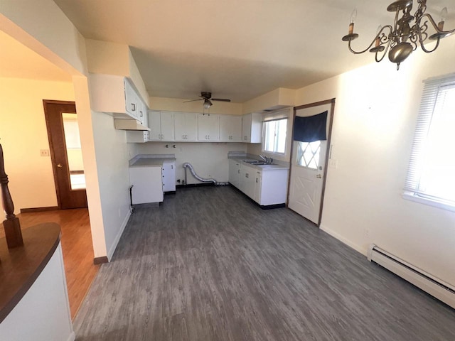 kitchen with ceiling fan with notable chandelier, a baseboard heating unit, sink, white cabinets, and dark hardwood / wood-style floors