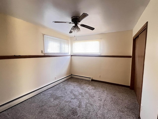 carpeted empty room featuring ceiling fan and a baseboard heating unit