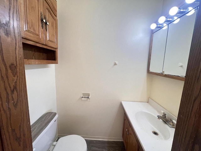 bathroom with vanity, wood-type flooring, and toilet