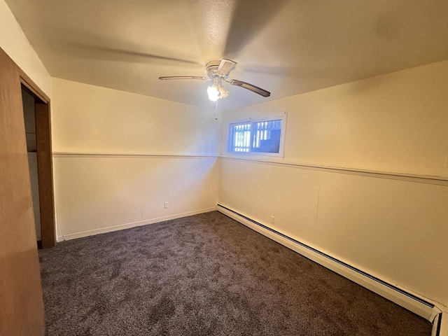 carpeted spare room with ceiling fan and a baseboard heating unit