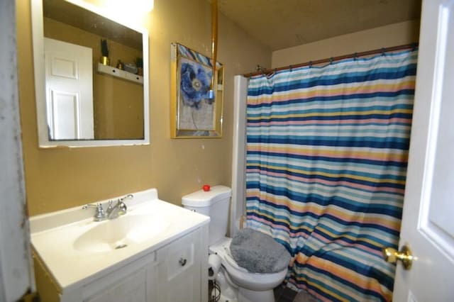 bathroom with vanity, toilet, and walk in shower