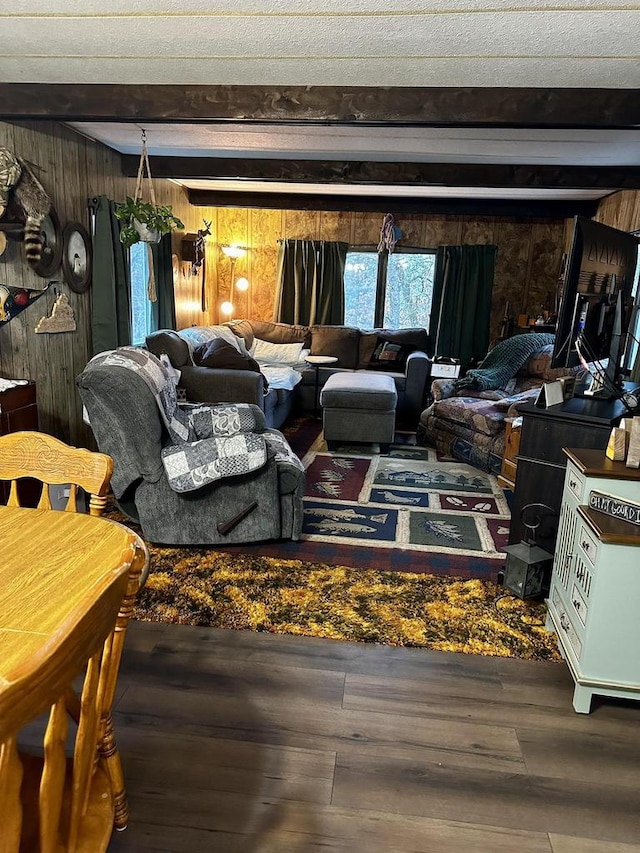 living room featuring wood walls, beam ceiling, and wood-type flooring