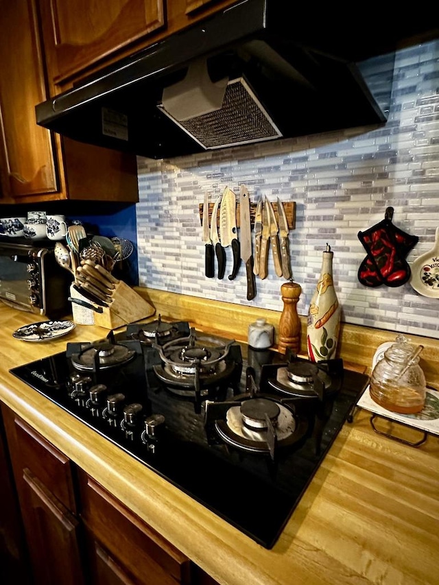 kitchen featuring wood counters, black gas cooktop, and exhaust hood