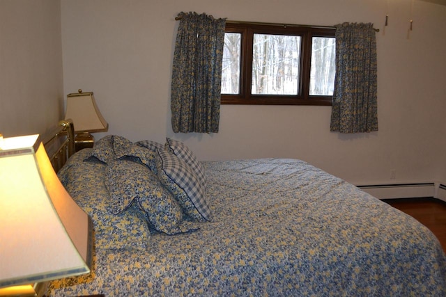 bedroom with hardwood / wood-style flooring and a baseboard heating unit