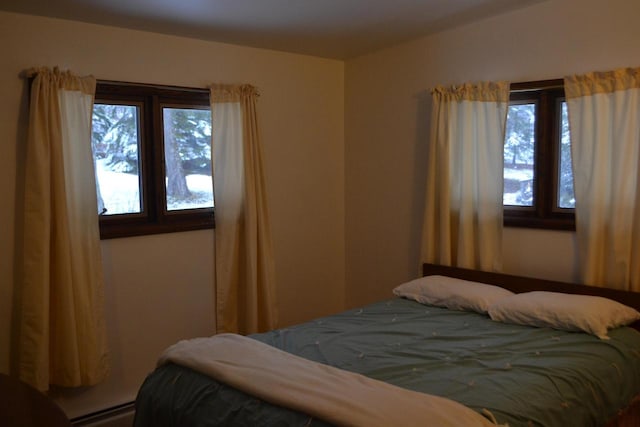 bedroom with baseboard heating and multiple windows