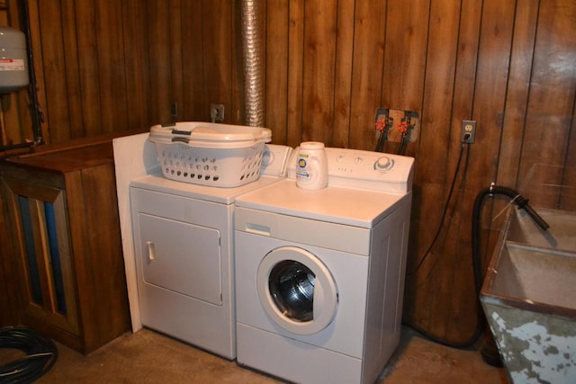 laundry room featuring washer and dryer and wooden walls