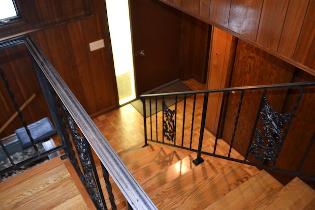 staircase with wooden walls and parquet floors