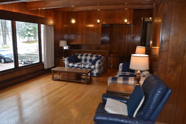 living area with hardwood / wood-style flooring, wooden walls, and a baseboard heating unit