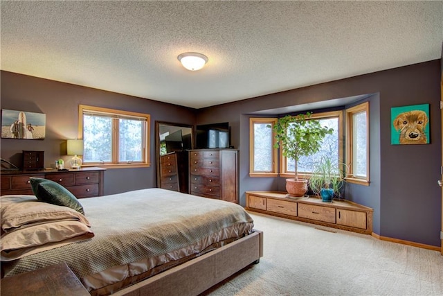 bedroom with a textured ceiling and light carpet