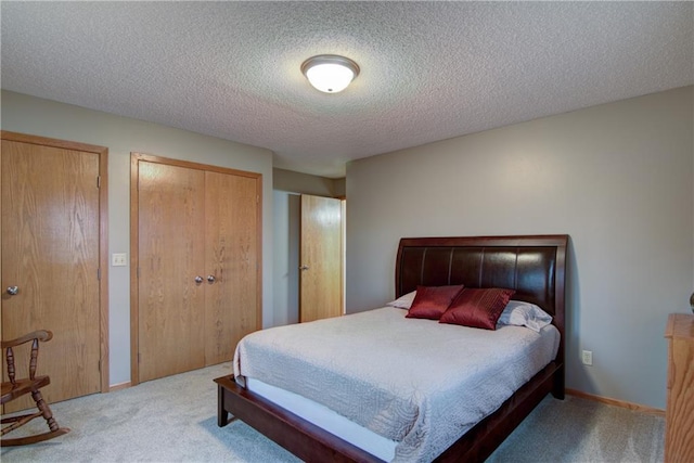 carpeted bedroom with a textured ceiling and multiple closets