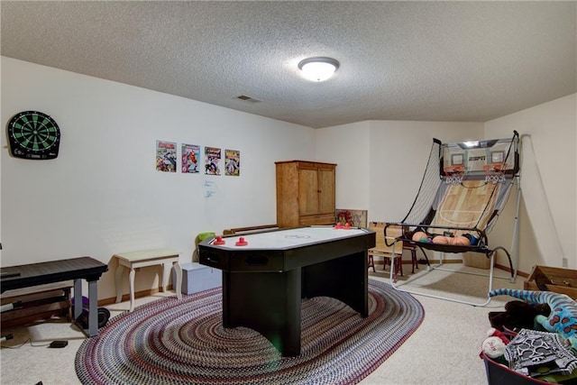 rec room featuring a textured ceiling and light colored carpet