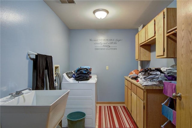 washroom with separate washer and dryer, sink, and cabinets