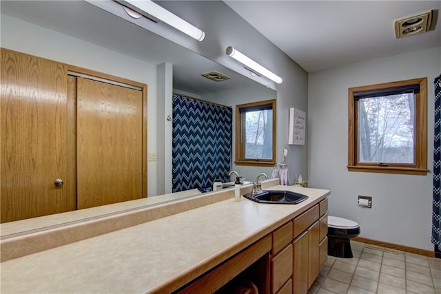 bathroom featuring tile patterned flooring, vanity, and toilet