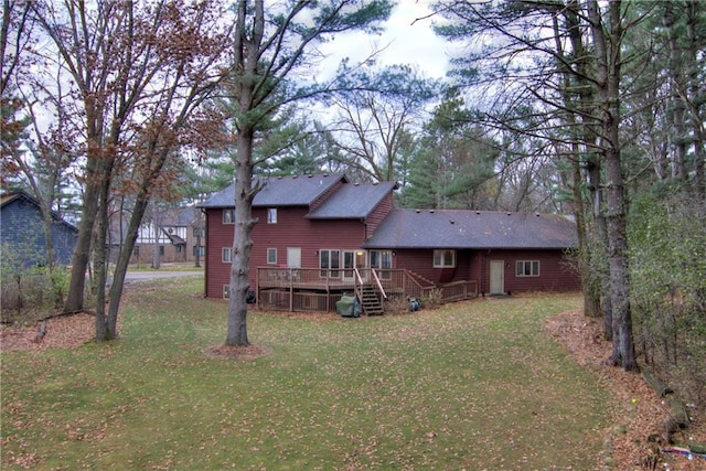 back of house featuring a lawn and a wooden deck