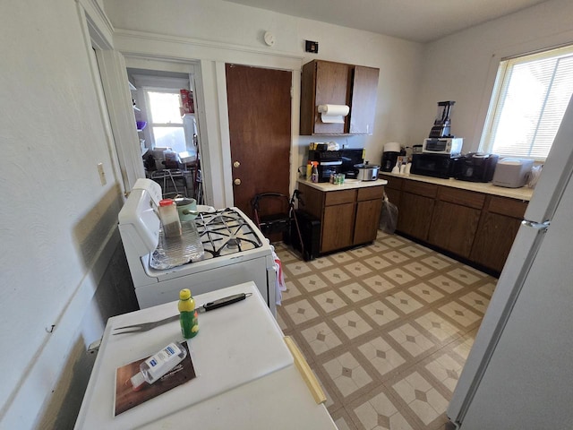 kitchen with dark brown cabinetry and white appliances