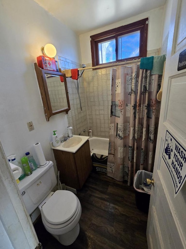 full bathroom featuring hardwood / wood-style floors, vanity, toilet, and shower / bath combo