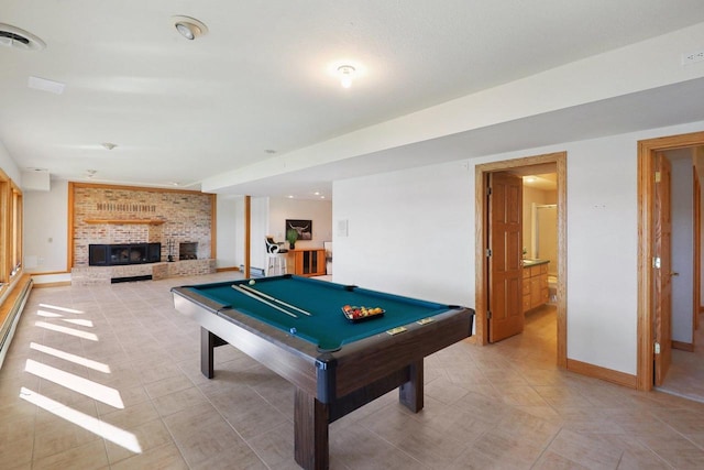 recreation room featuring a brick fireplace, light tile patterned flooring, and pool table