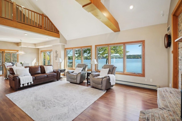 living room with a water view, dark wood-type flooring, a wealth of natural light, and a baseboard radiator