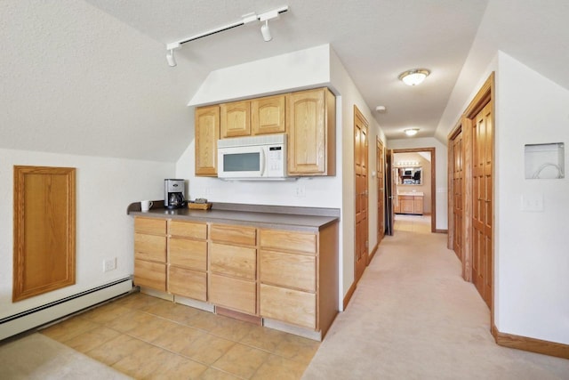 kitchen with a textured ceiling, light carpet, and a baseboard heating unit