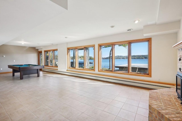 recreation room with a water view, light tile patterned floors, a fireplace, and billiards