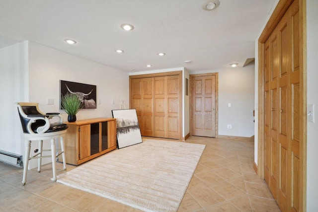 living area with light tile patterned floors and baseboard heating