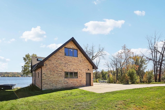 view of side of property with a lawn, a garage, and a water view