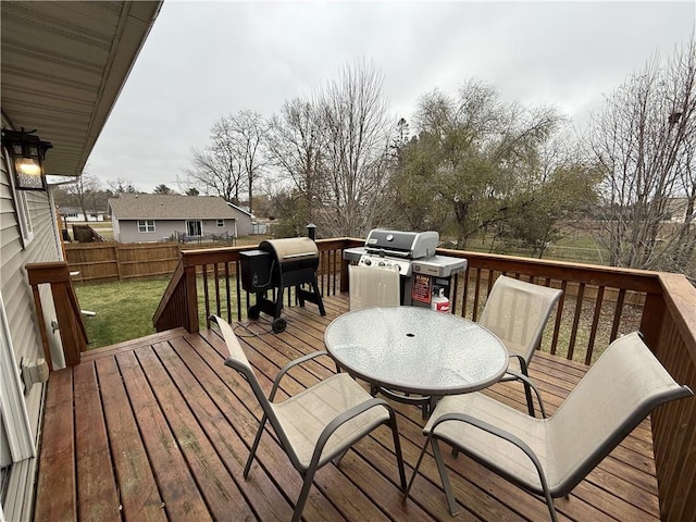 wooden deck with a grill and a lawn