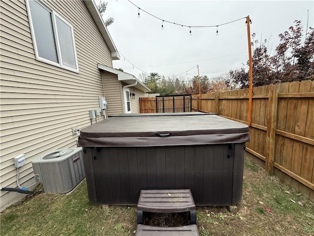 view of yard with central AC and a hot tub