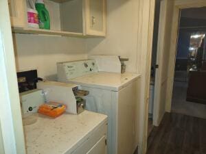 clothes washing area featuring cabinets, dark wood-type flooring, and washer and dryer