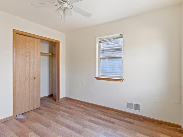 unfurnished bedroom with ceiling fan, a closet, and light wood-type flooring