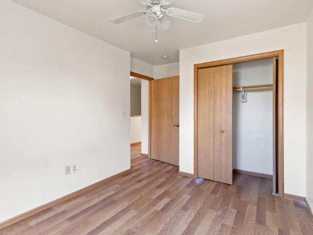 unfurnished bedroom with hardwood / wood-style flooring, ceiling fan, and a closet