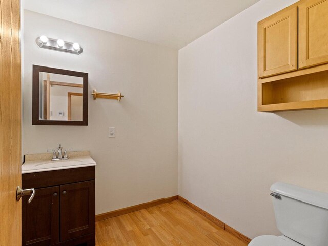 bathroom featuring vanity, toilet, and wood-type flooring