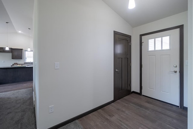 entrance foyer with dark hardwood / wood-style floors and vaulted ceiling