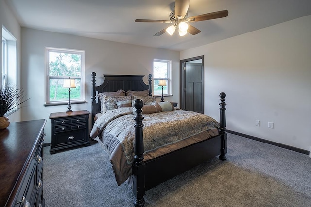 bedroom with multiple windows, ceiling fan, and dark carpet