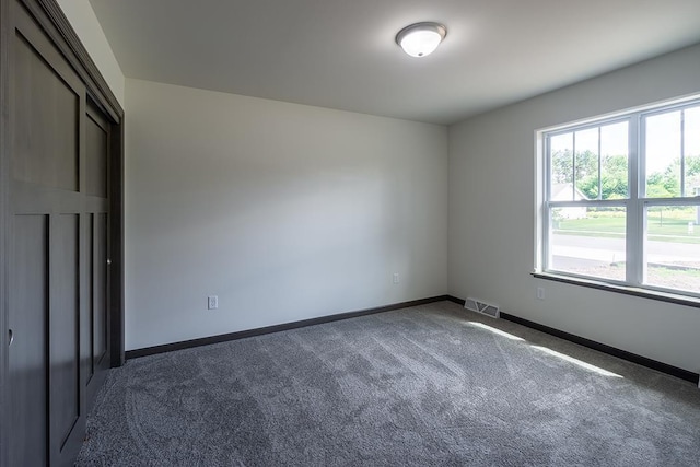 unfurnished bedroom featuring dark colored carpet