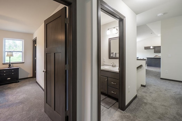 corridor featuring light carpet and sink