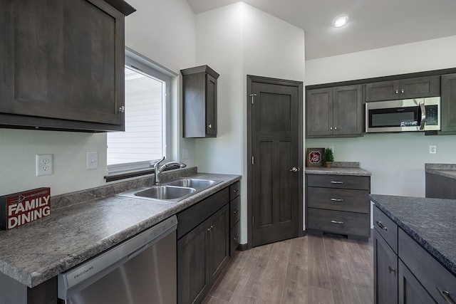 kitchen featuring hardwood / wood-style flooring, sink, dark brown cabinets, and appliances with stainless steel finishes