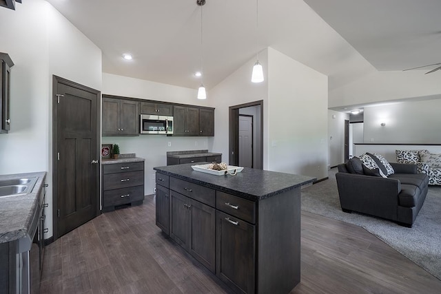 kitchen featuring dark hardwood / wood-style floors, a kitchen island, dark brown cabinetry, and lofted ceiling