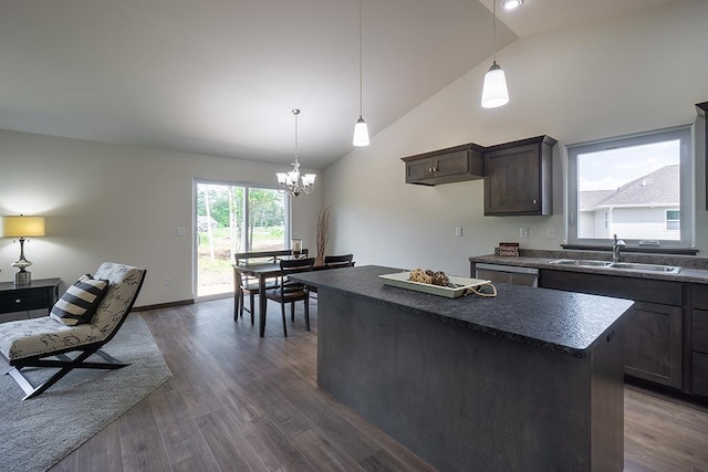 kitchen featuring dark hardwood / wood-style flooring, dark brown cabinets, sink, an inviting chandelier, and a center island