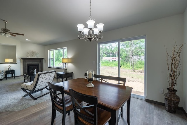 dining area featuring ceiling fan with notable chandelier and hardwood / wood-style flooring