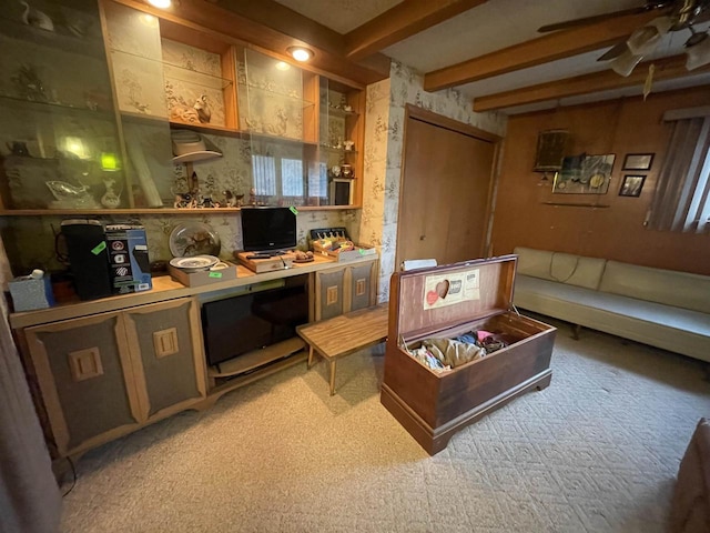 interior space with carpet, ceiling fan, and beam ceiling