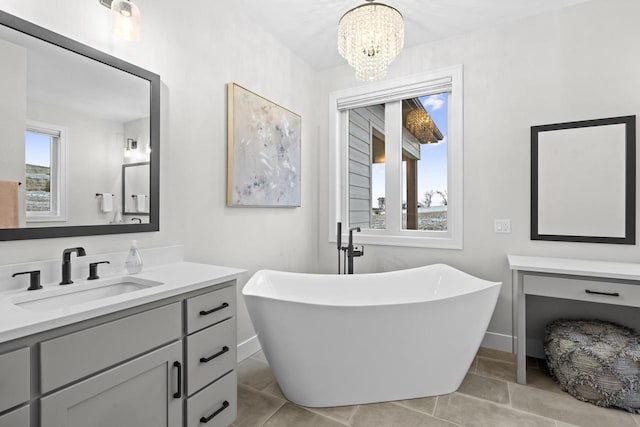 bathroom featuring a chandelier, plenty of natural light, a bath, and vanity