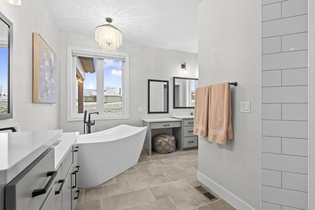 bathroom with vanity, a bath, and an inviting chandelier